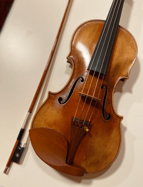Handmade violin on a table with a violin bow