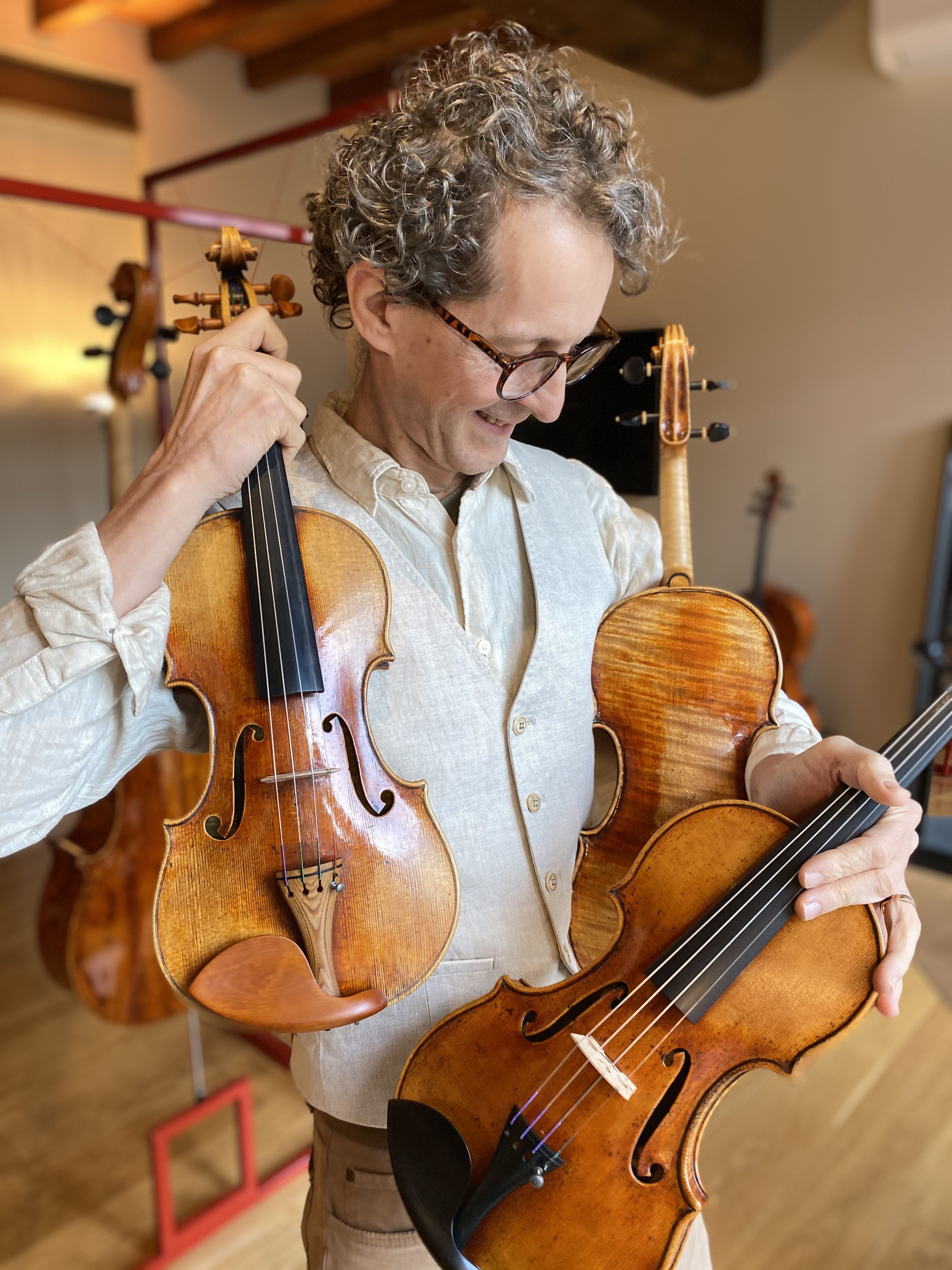 Violin Maker holding three of his best violins