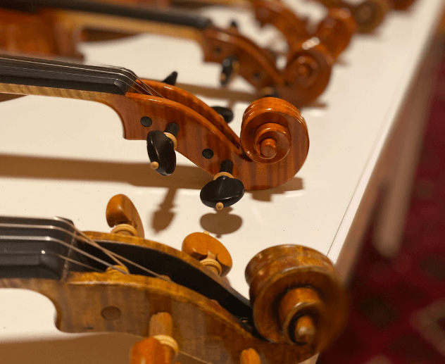 two violins head and scroll at a table