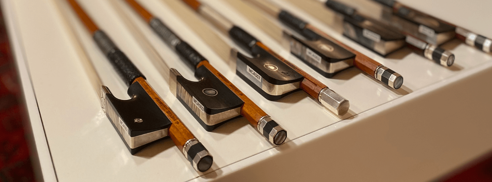 violin bow making - handcrafted violins bows side by side on a table Mio Cannone Violini
