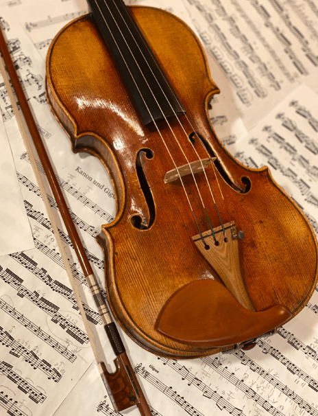 classical music pieces Handcrafted Violin and Bow above music sheets