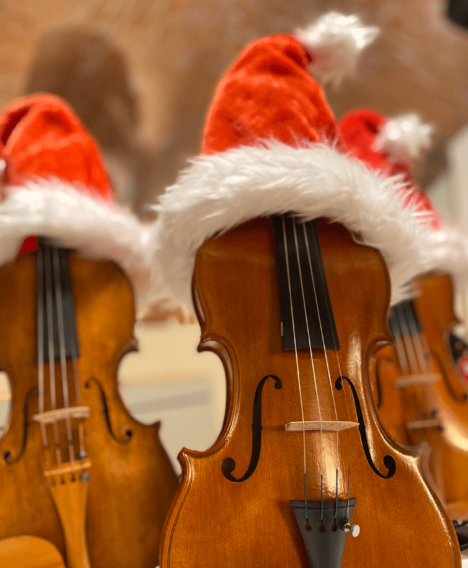 Three Handmade violins with christmas hat
